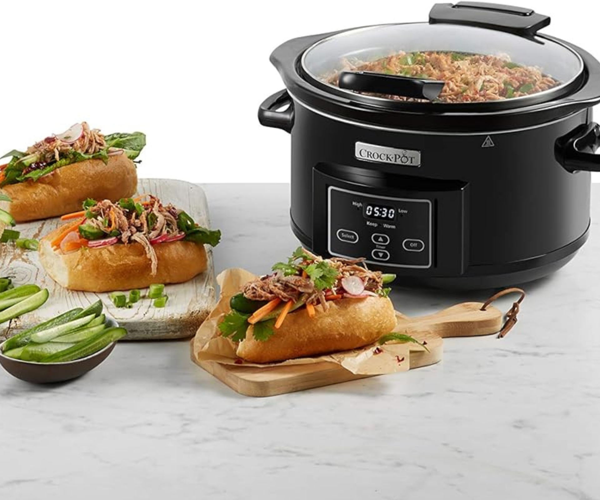 A Crock-Pot surrounded by slow cooked meats
